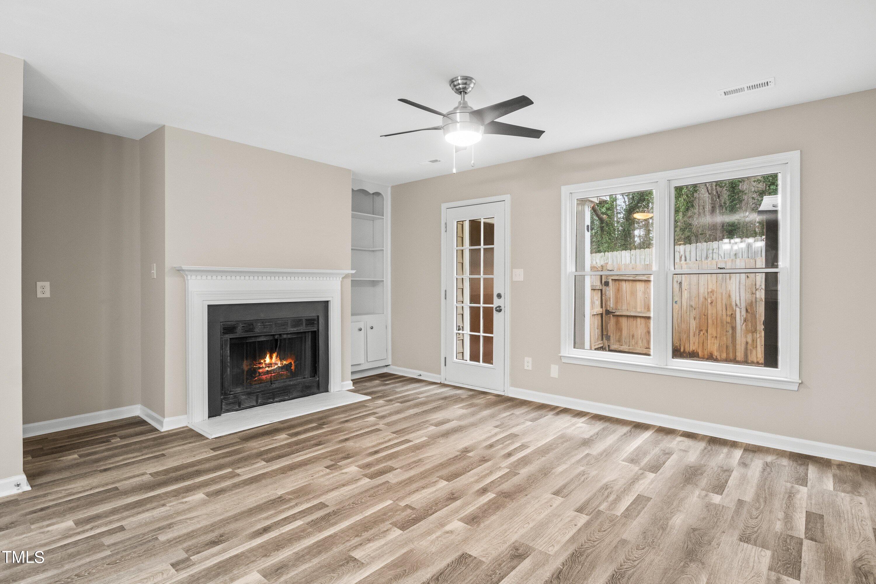 4440 Roller Court Raleigh, NC 27604 - Photo 10 of 38 a view of an empty room with wooden floor fireplace and a window