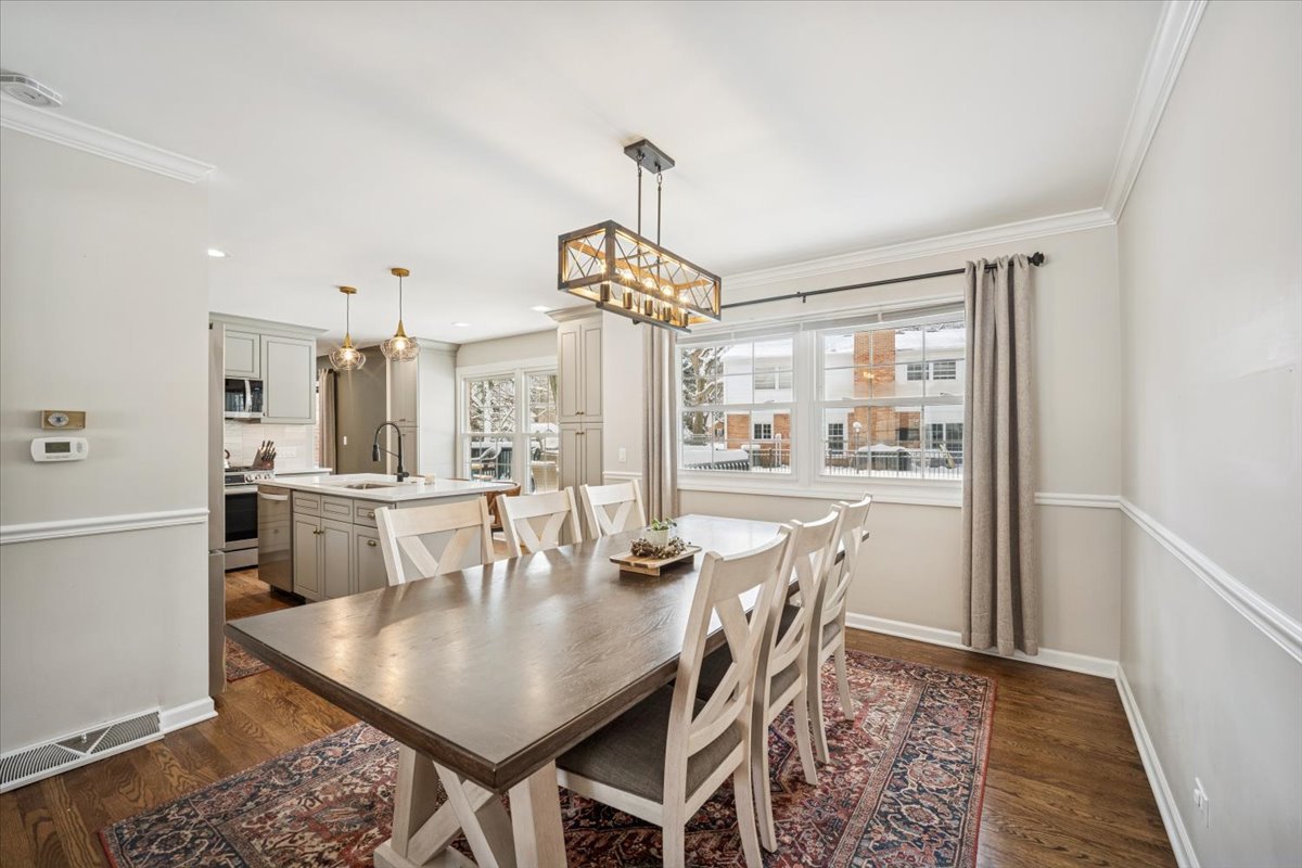 1718 South Ridge Drive Arlington Heights, IL 60005 - Photo 5 of 35 a dining room with furniture a chandelier and wooden floor