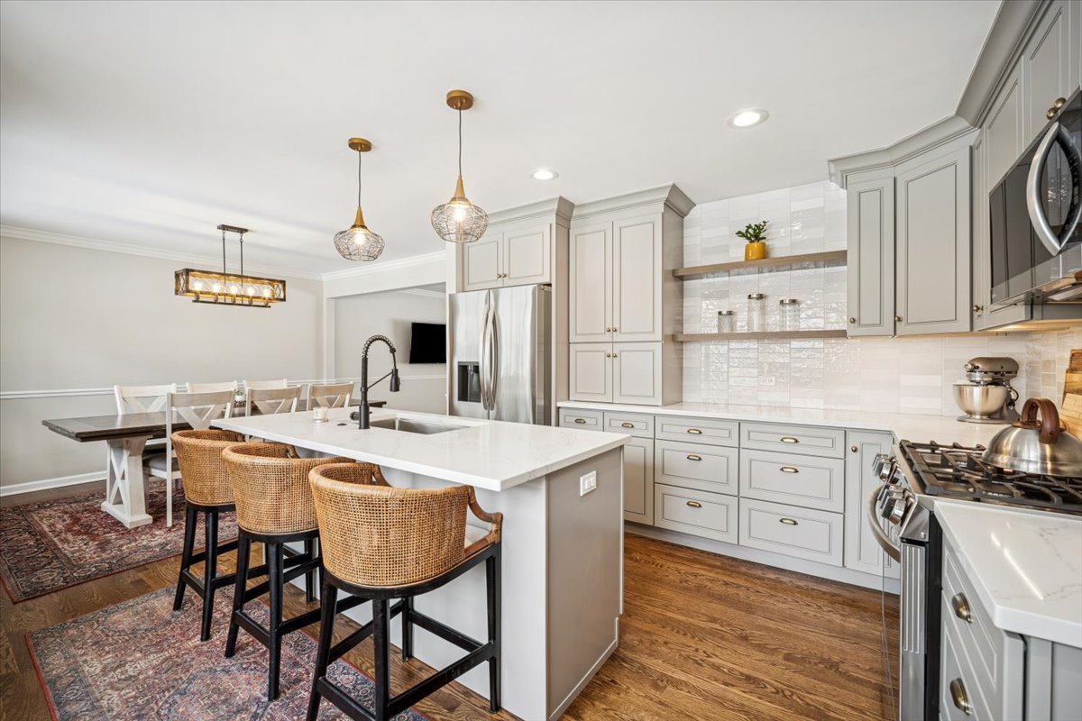 1718 South Ridge Drive Arlington Heights, IL 60005 - Photo 9 of 35 a kitchen with a stove a sink a dining table and chairs