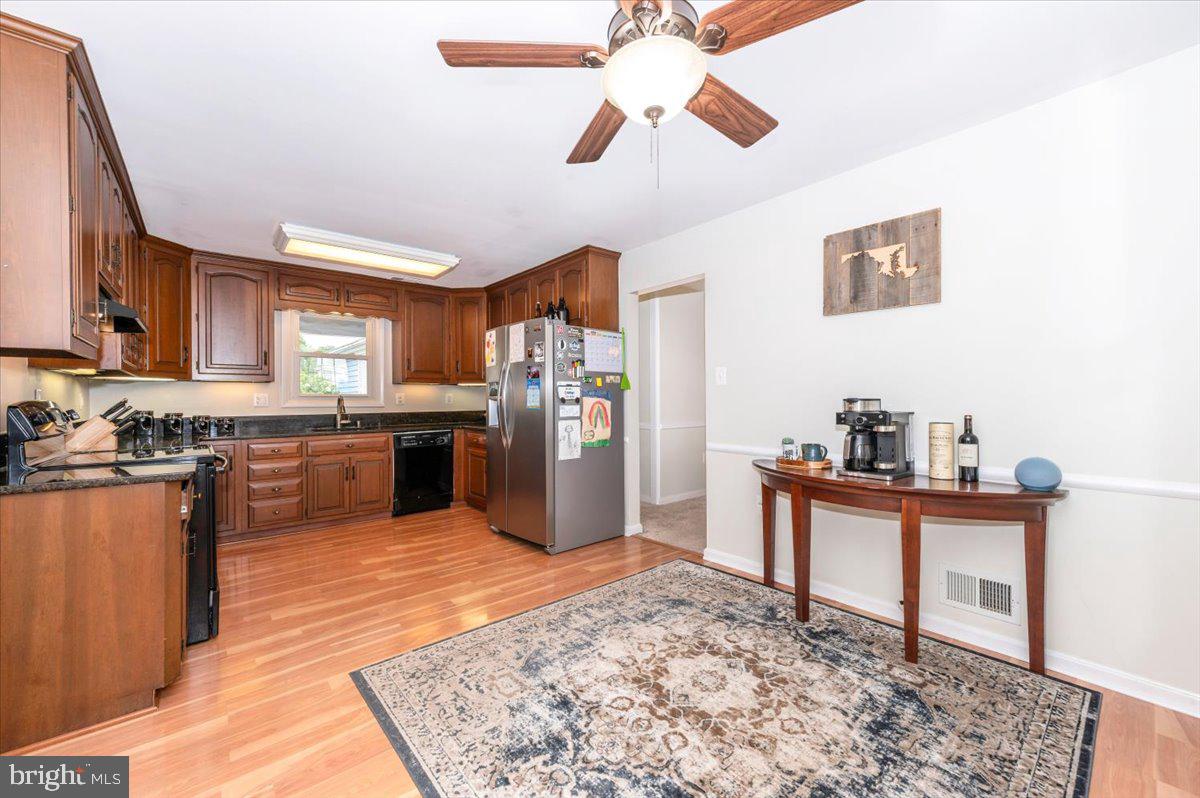 17305 Fletchall Road Poolesville, MD 20837 - Photo 15 of 51 a kitchen with stainless steel appliances kitchen island granite countertop a refrigerator a stove top oven a sink and dishwasher