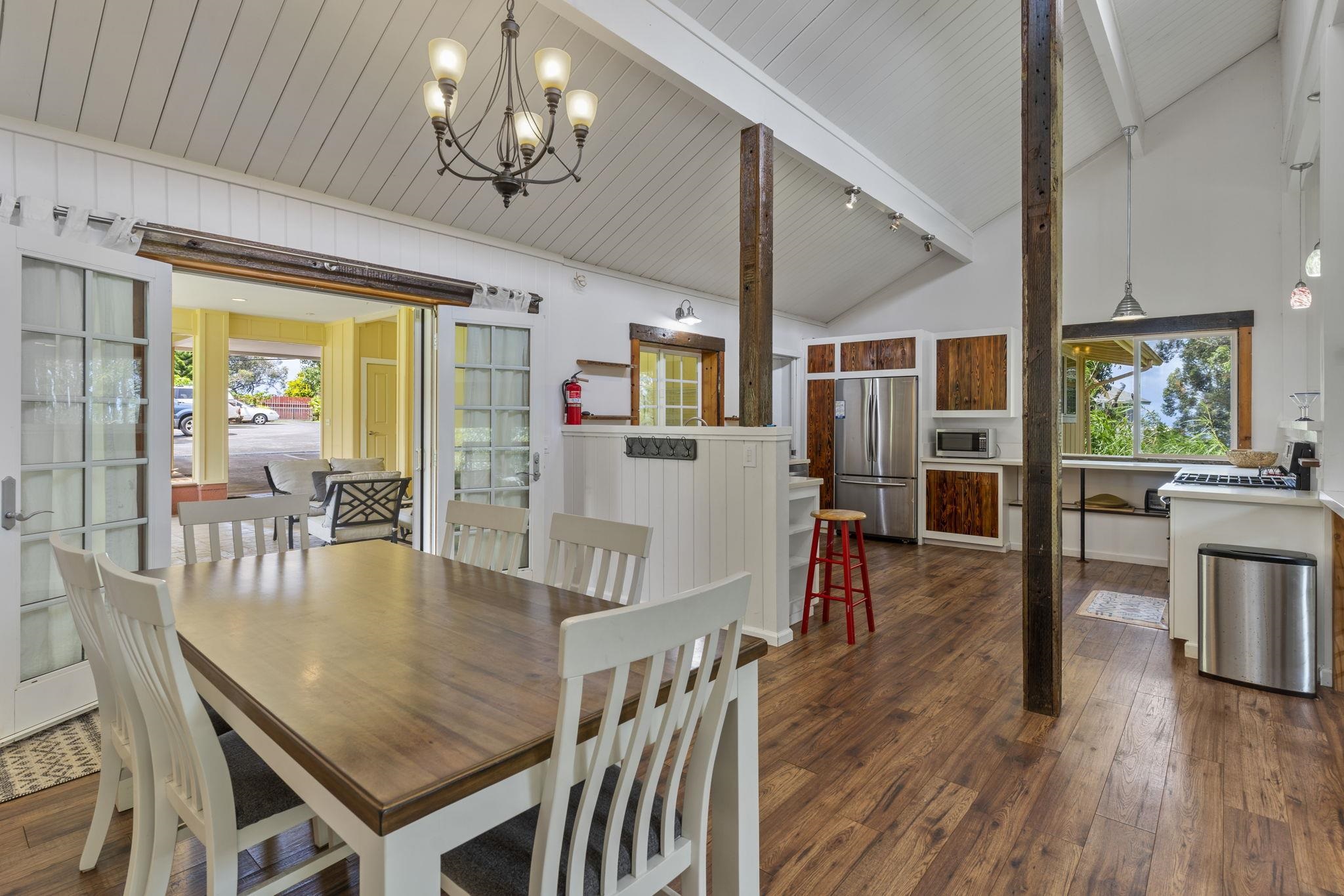 1515 Kaupakalua Road Haiku, HI 96708 - Photo 12 of 45 a dining room with wooden floor a chandelier a glass table and chairs