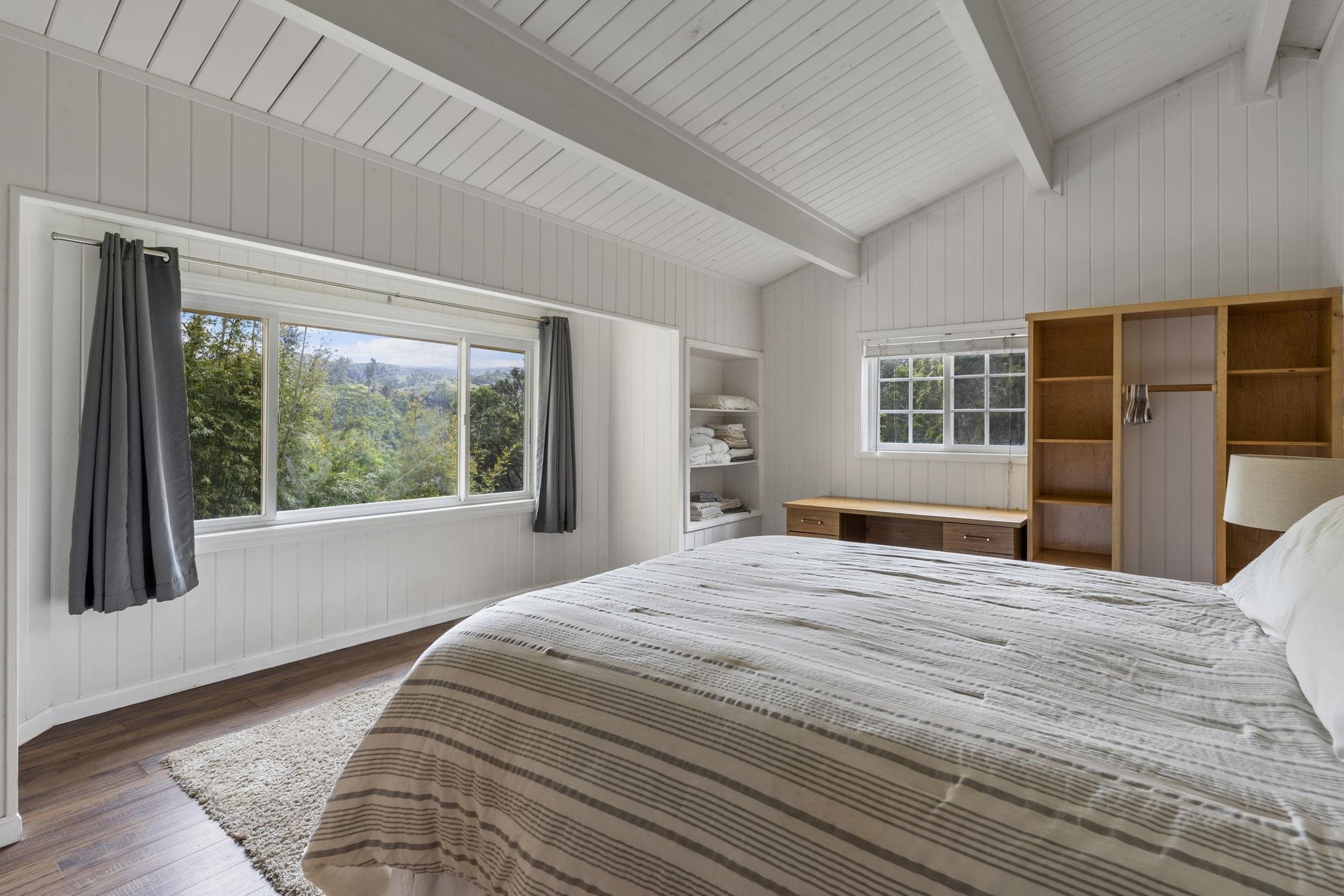 1515 Kaupakalua Road Haiku, HI 96708 - Photo 17 of 45 a bedroom with a large bed windows and wooden floor
