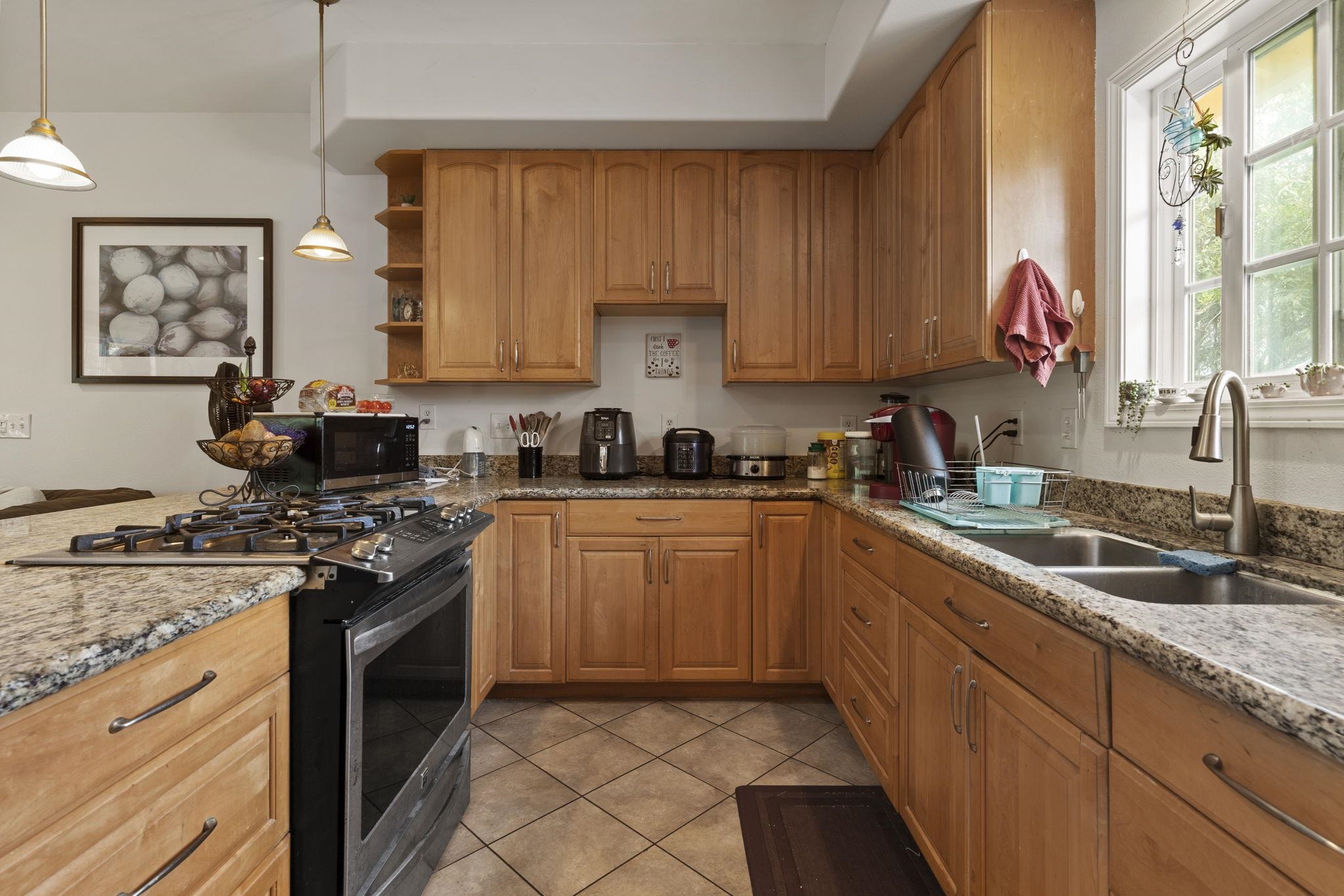 1515 Kaupakalua Road Haiku, HI 96708 - Photo 24 of 45 a kitchen with granite countertop a stove sink and cabinets