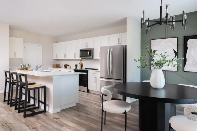 a kitchen with a table chairs refrigerator and microwave