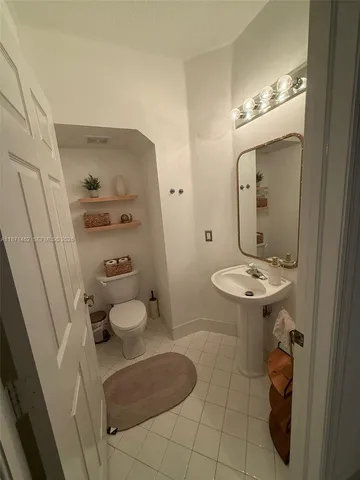 a bathroom with a sink a toilet and mirror