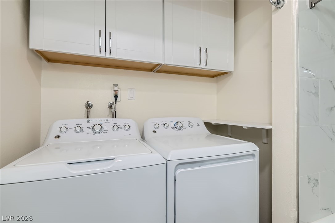3665 Bronco Road Las Vegas, NV 89103 - Photo 22 of 28 Streamlined laundry area with a dedicated washer and dryer beneath practical overhead cabinetry.