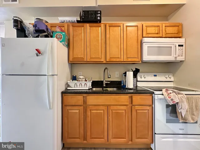 a kitchen with stainless steel appliances granite countertop a refrigerator and a stove