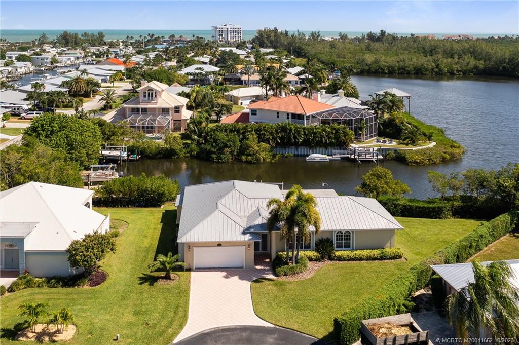 103 Aqua Ra Drive Jensen Beach, FL 34957 - Photo 2 of 48 an aerial view of a house with swimming pool and lake view