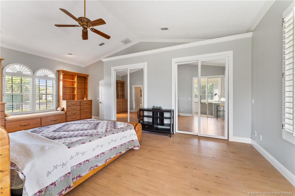 103 Aqua Ra Drive Jensen Beach, FL 34957 - Photo 31 of 48 a bedroom with a large bed a flat screen tv and couches next to a window