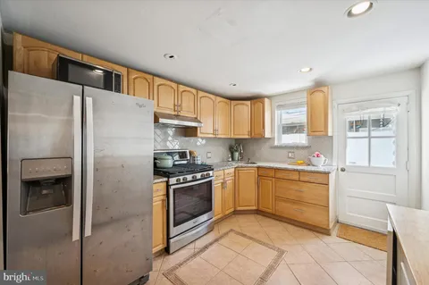 a kitchen with stainless steel appliances granite countertop a refrigerator and a stove top oven
