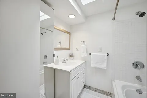 a bathroom with a sink a tub and a mirror