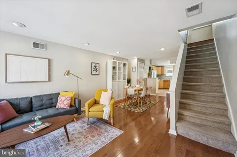 a living room with furniture and wooden floor