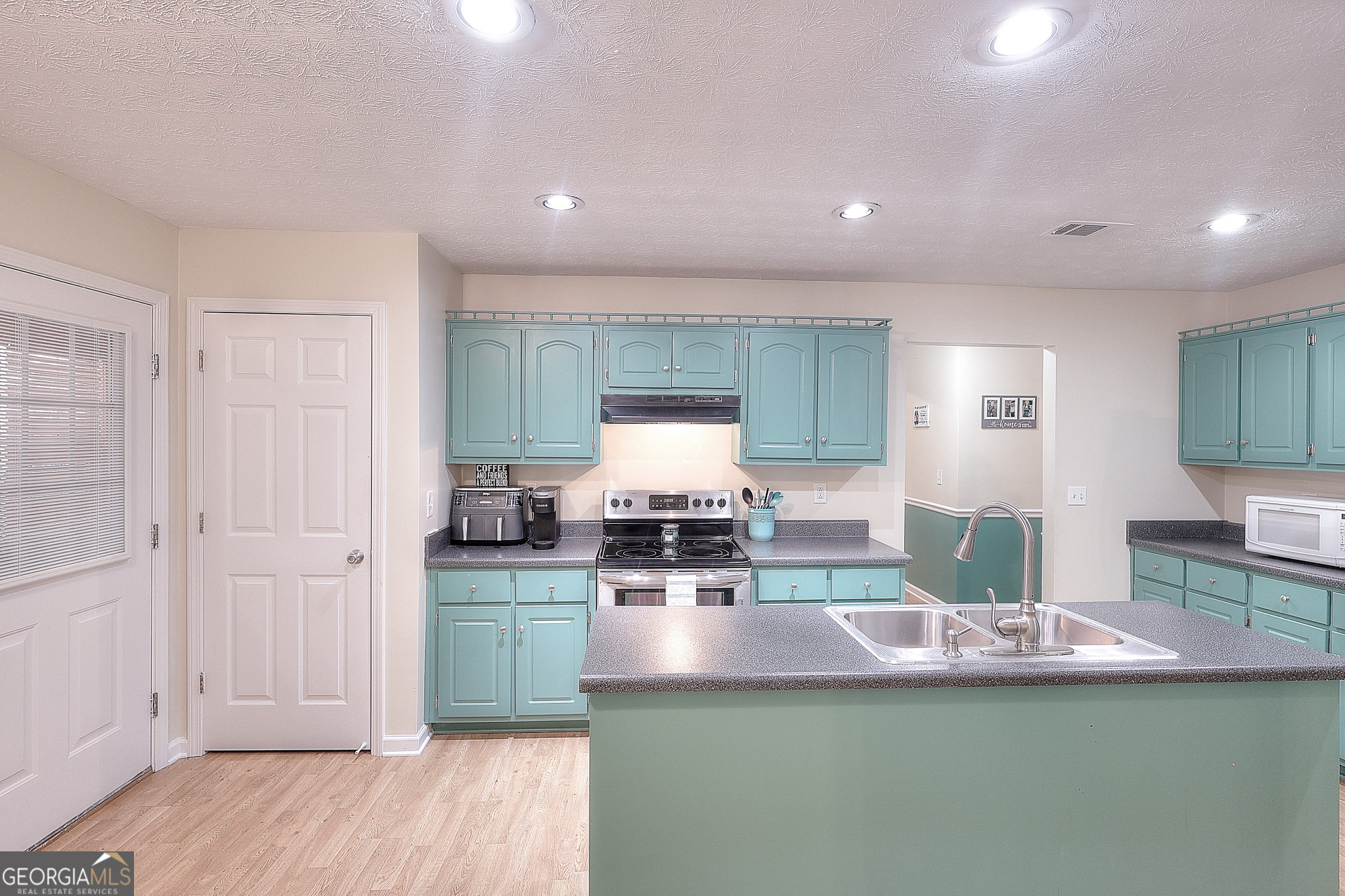 245 Tamea Trail Covington, GA 30014 - Photo 8 of 31 a view of a living room kitchen with furniture and wooden floor
