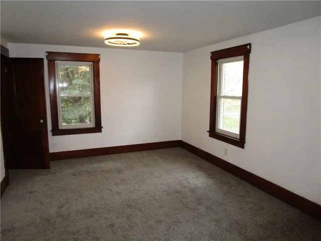 an empty room with windows and closet