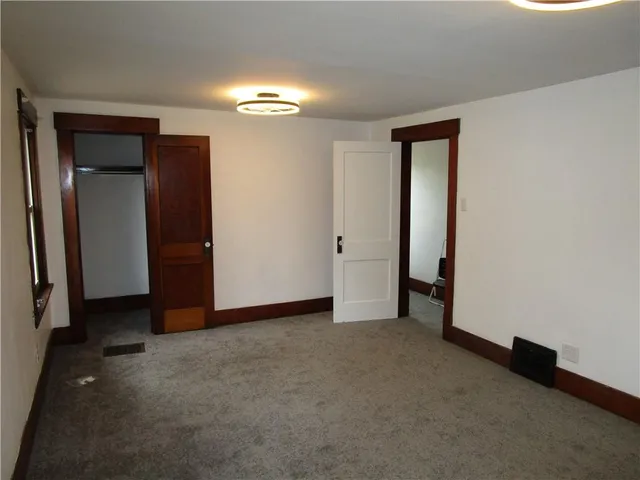 an empty room with closet and a bathroom