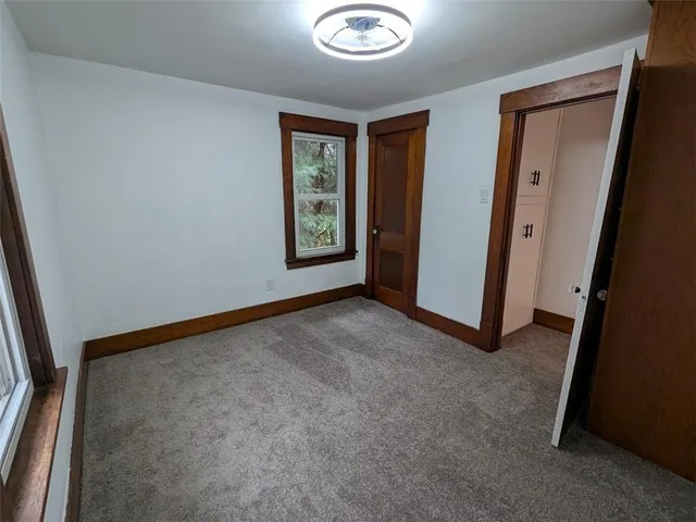 an empty room with windows and closet