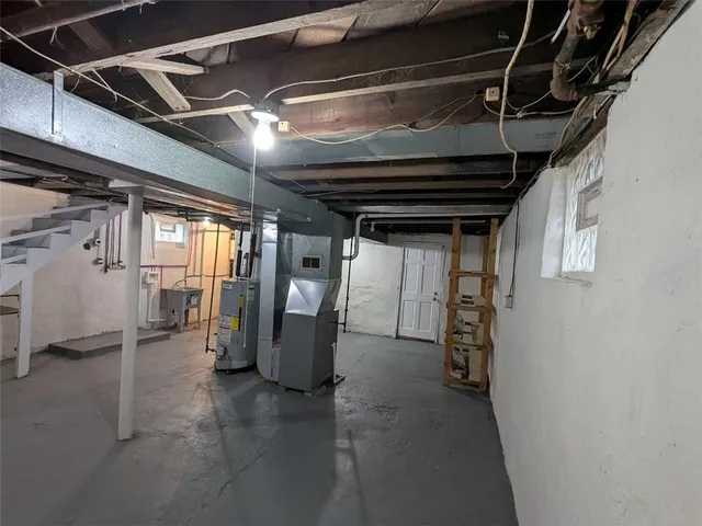 a view of water heater room with wooden floor