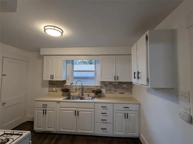 a kitchen with granite countertop white cabinets and white appliances