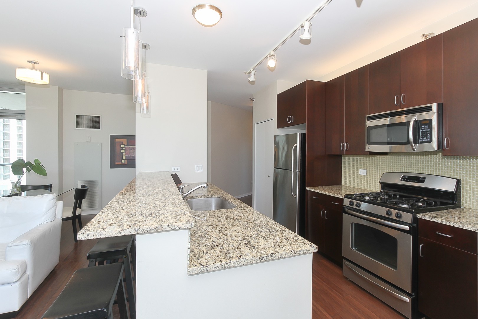 123 South Green Street, Unit 801B Chicago, IL 60607 - Photo 7 of 20 a kitchen with stainless steel appliances granite countertop a sink stove and refrigerator