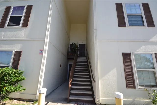 a view of a white house with a yard and plants