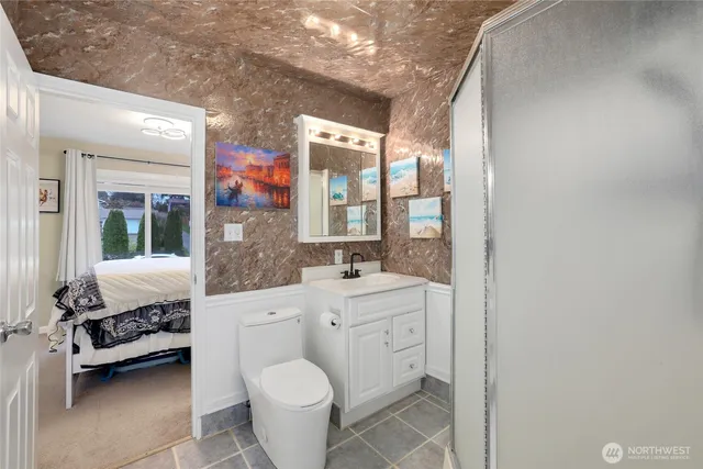 a spacious bathroom with a toilet a sink and a mirror