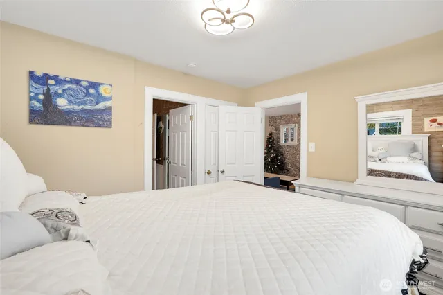 a bedroom with a large bed and a chandelier