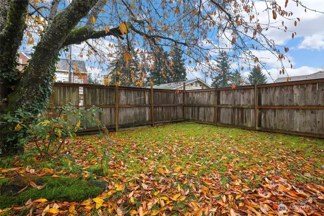 a view of backyard with wooden fence
