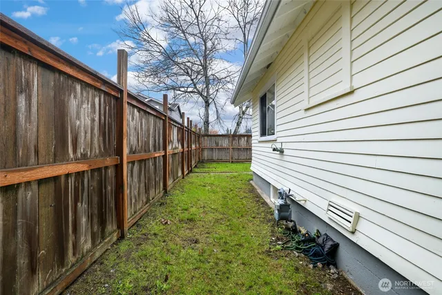 a view of a backyard with wooden fence