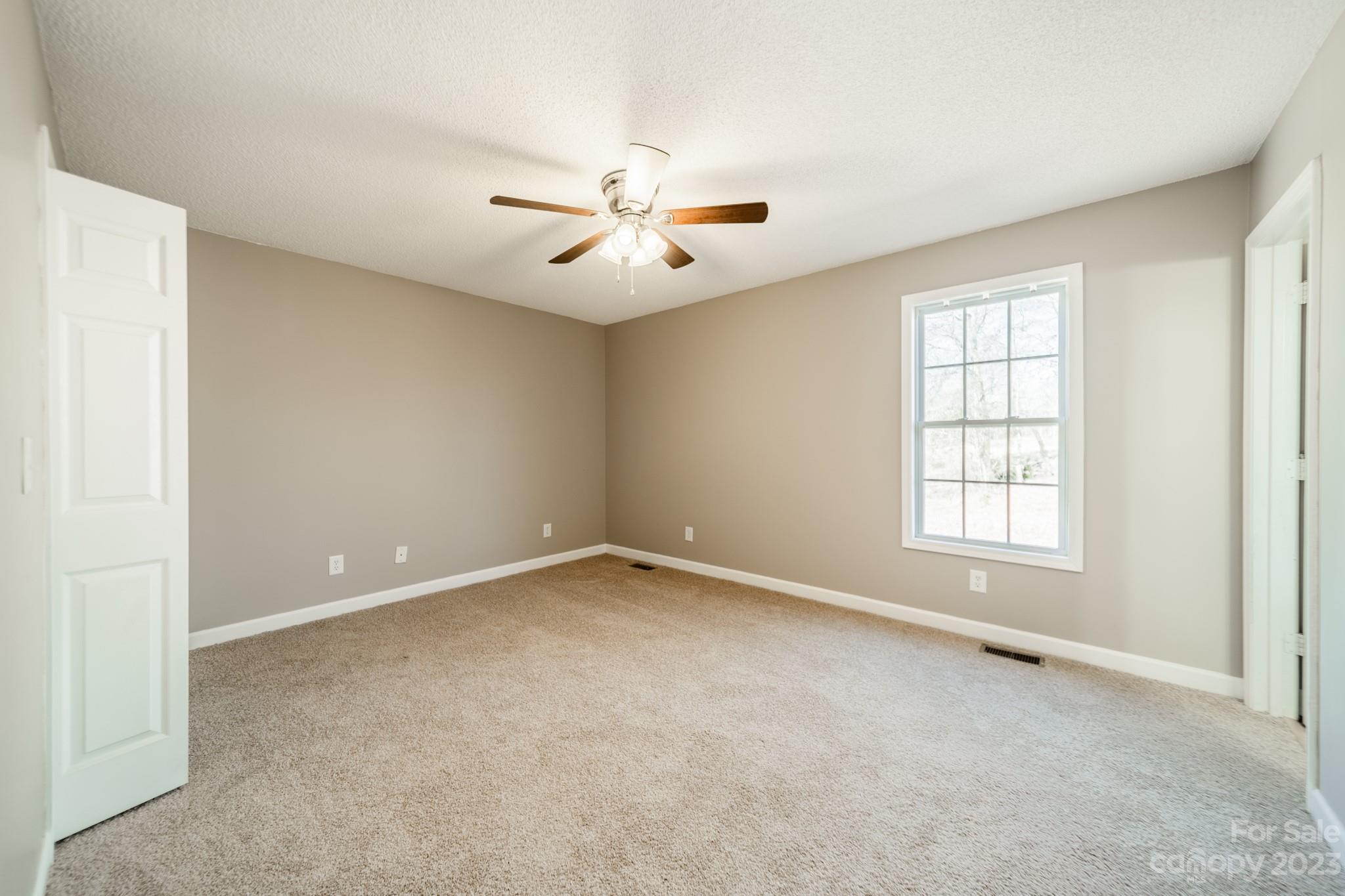 300 Walkers Ridge Drive Shelby, NC 28152 - Photo 10 of 15 an empty room with chandelier fan and windows