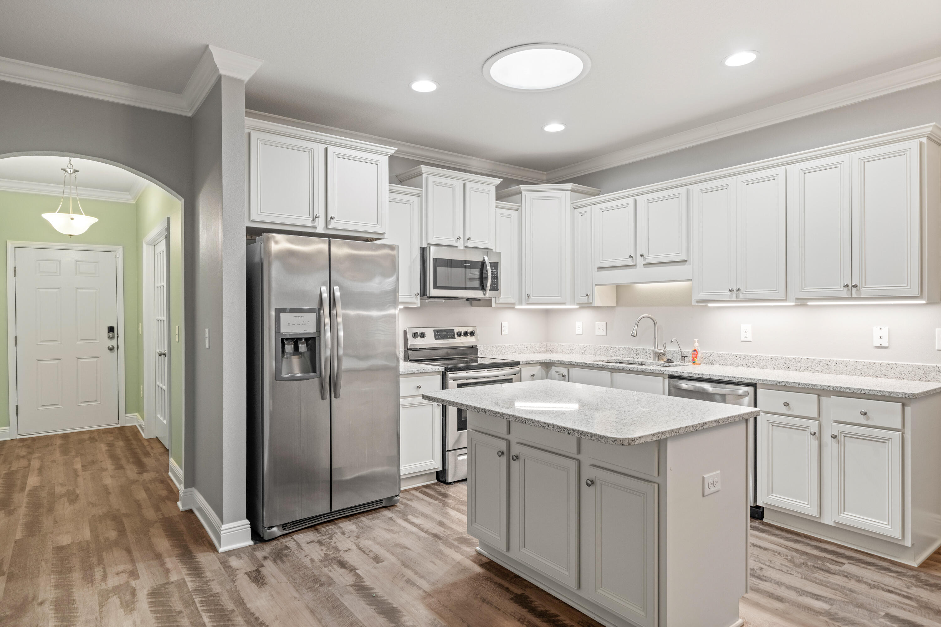 521 Cornelia Street Freeport, FL 32439 - Photo 11 of 39 a kitchen with white cabinets and stainless steel appliances