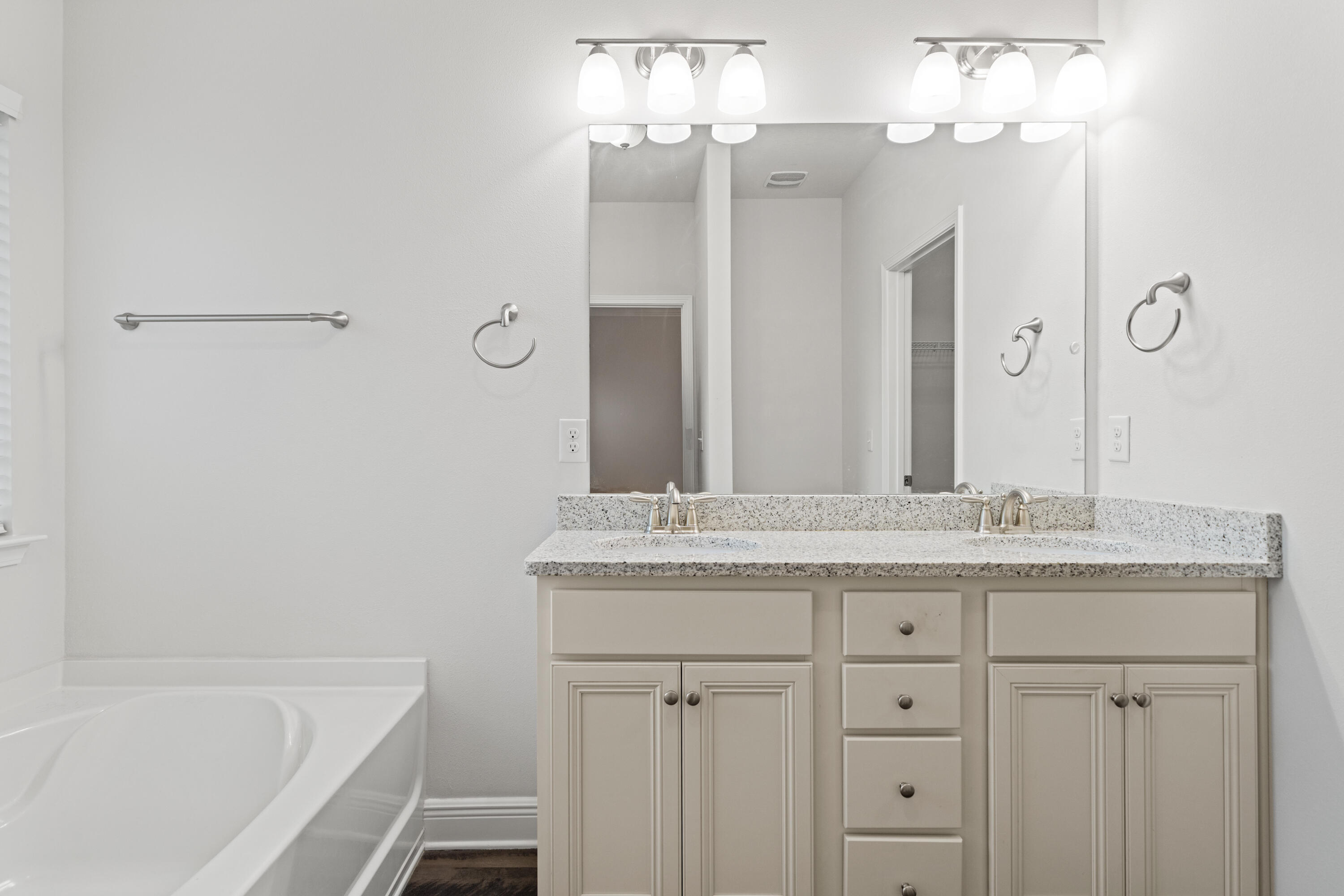 521 Cornelia Street Freeport, FL 32439 - Photo 23 of 39 a bathroom with a granite countertop sink a mirror and a bathtub