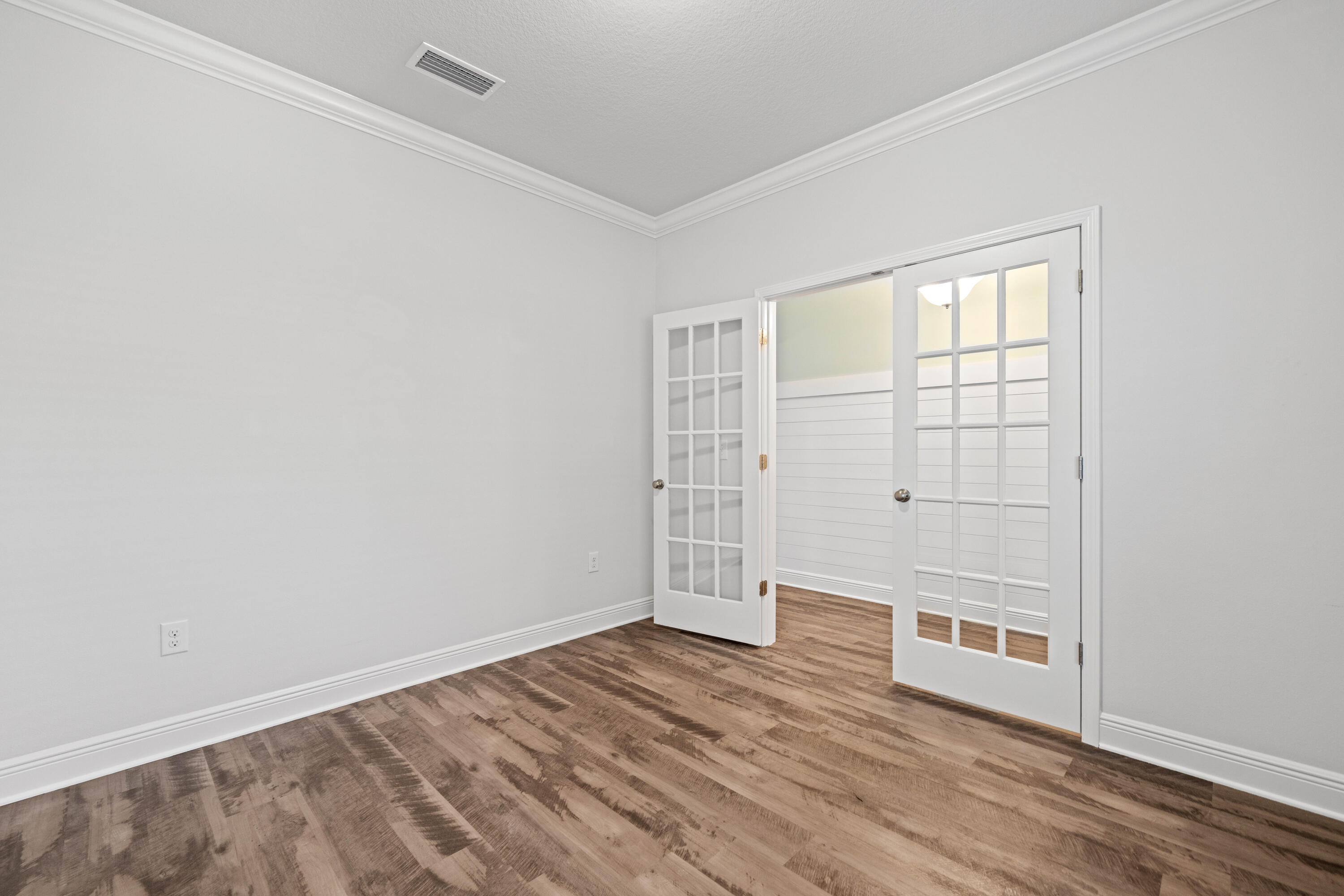 521 Cornelia Street Freeport, FL 32439 - Photo 9 of 39 an empty room with wooden floor and windows