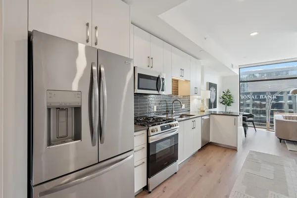 a kitchen with a refrigerator and a stove top oven