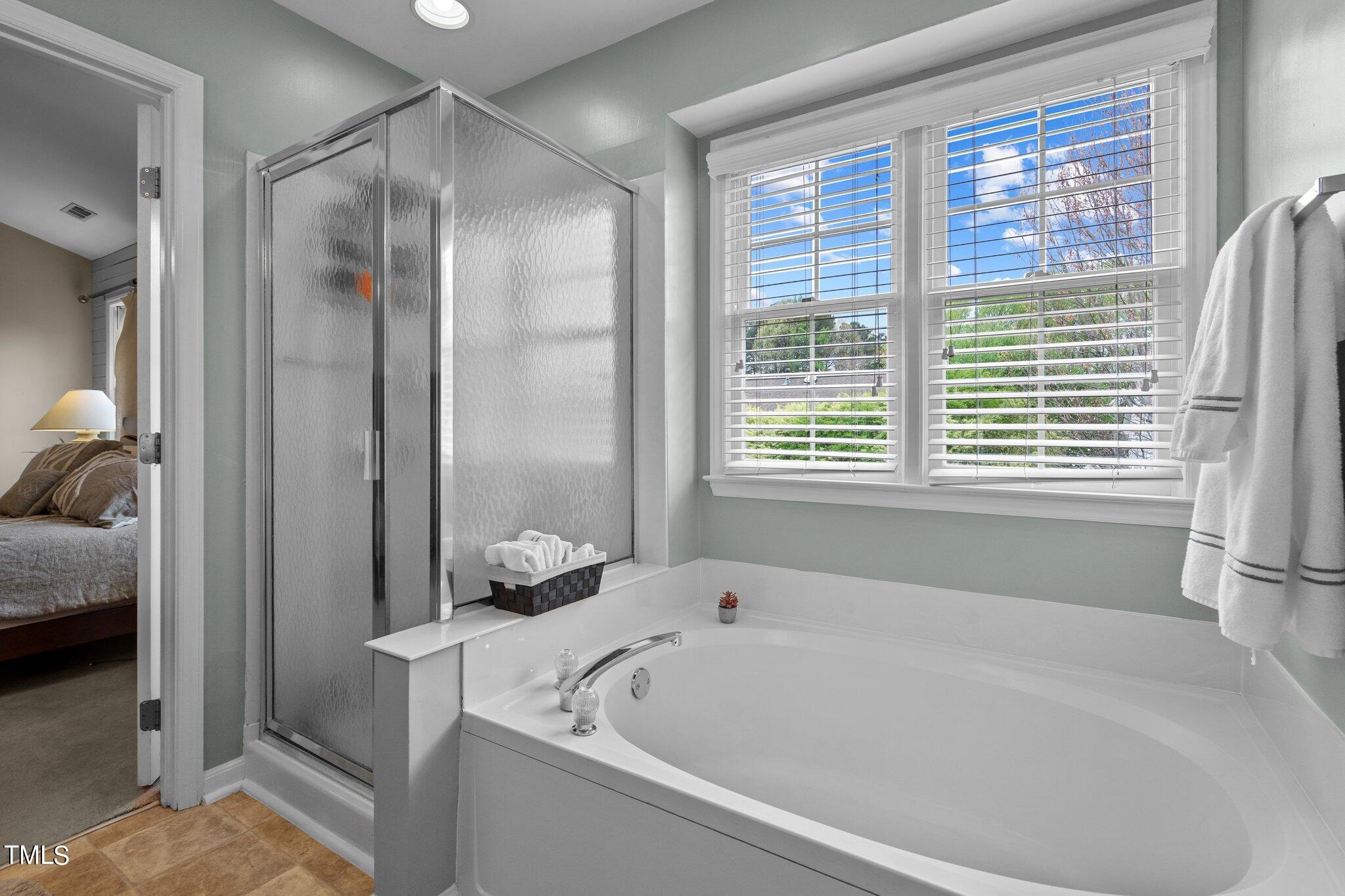 11328 North Radner Way Raleigh, NC 27613 - Photo 34 of 48 a bathroom with a bathtub and a shower