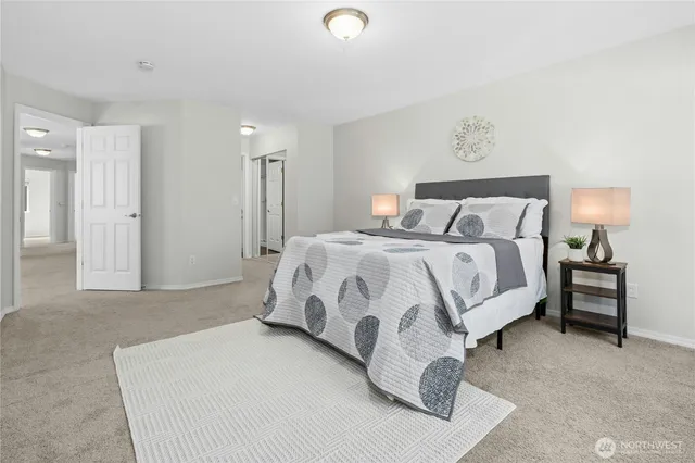 a spacious bedroom with a bed and a lamp