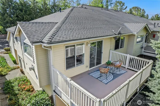 a view of a house with wooden deck and furniture