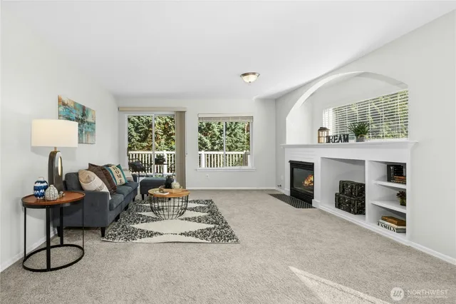 a living room with furniture a fireplace and a window