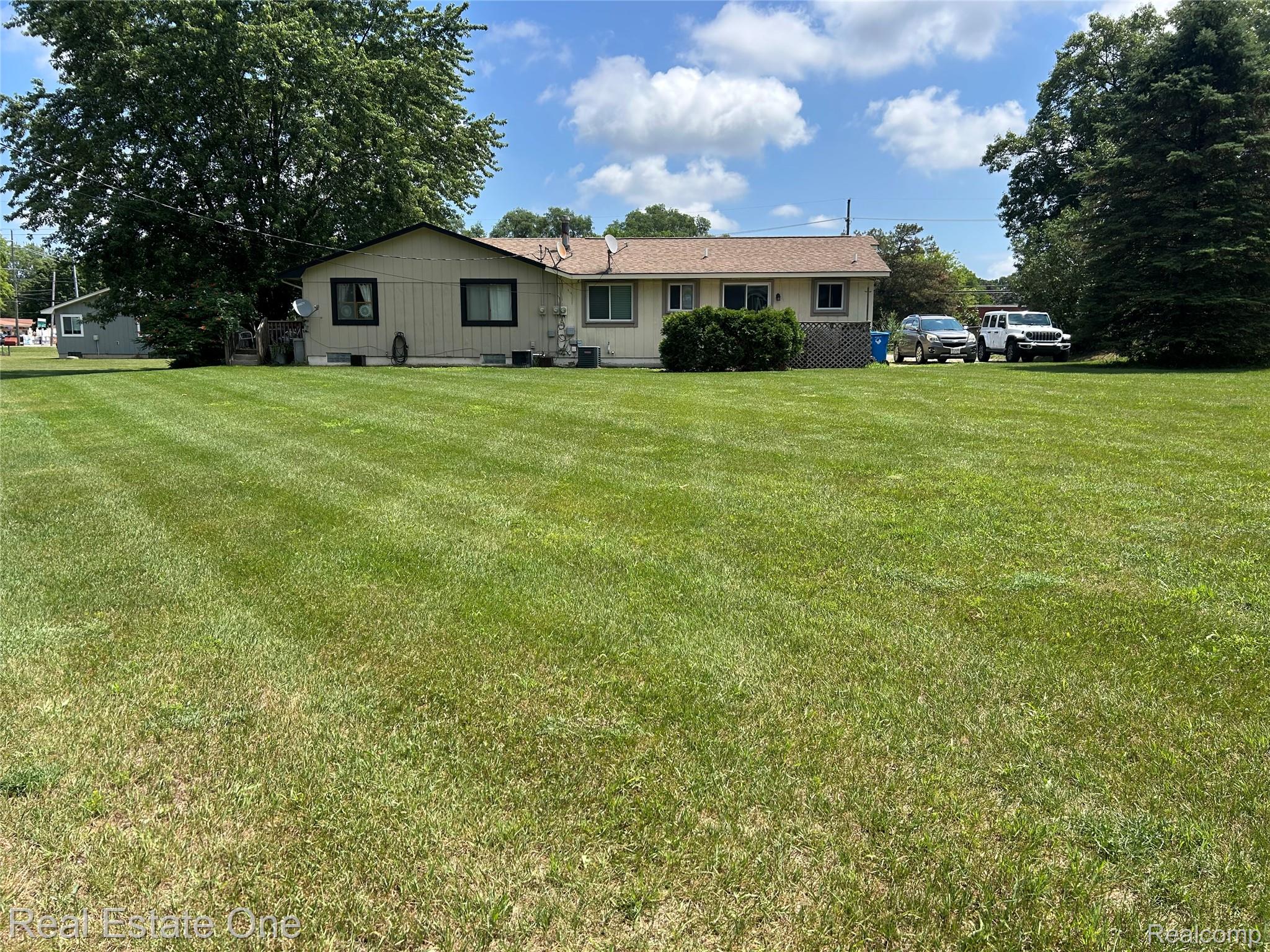 2659 Benstein Road Commerce Township, MI 48382 - Photo 3 of 26 Expansive green lawn with mature trees providing natural shading