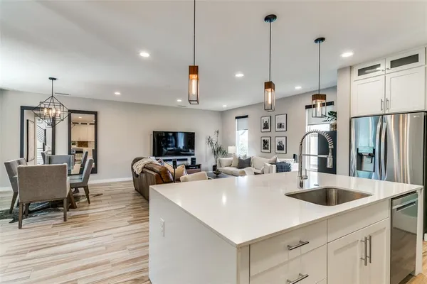 a kitchen that has a sink a counter space and stainless steel appliances