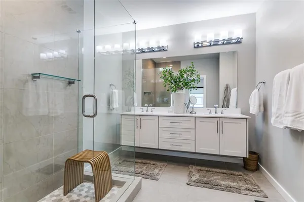 a bathroom with a double vanity sink mirror and shower