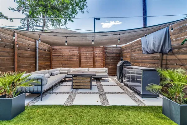 a roof deck with a couch and potted plants