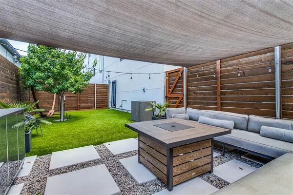 a view of a backyard with couches plants and large tree