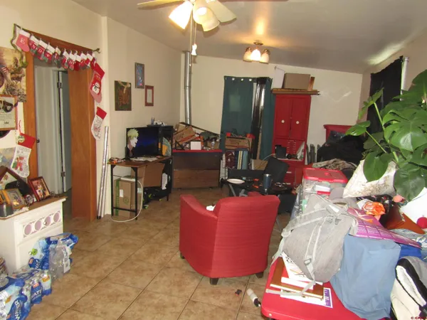 a living room with furniture a chandelier and a flat screen tv