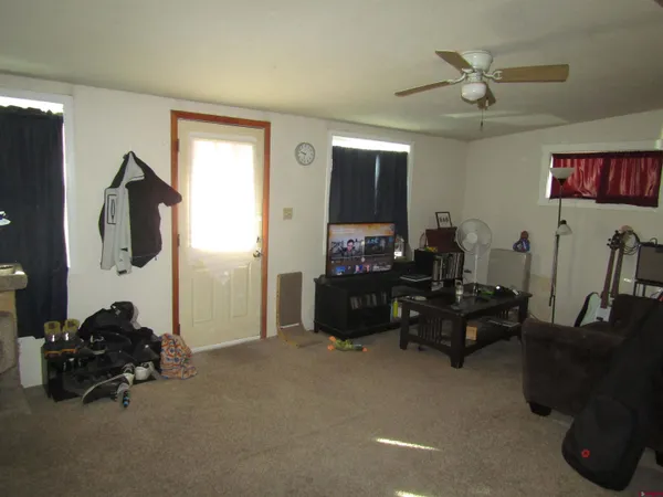 a living room with furniture a flat screen tv and a window