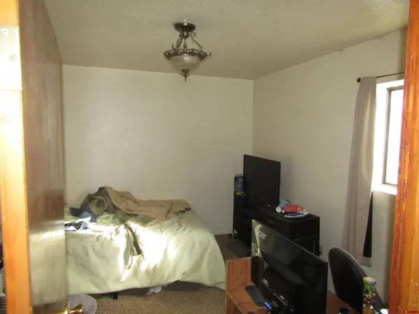 a bedroom with a bed and a chandelier