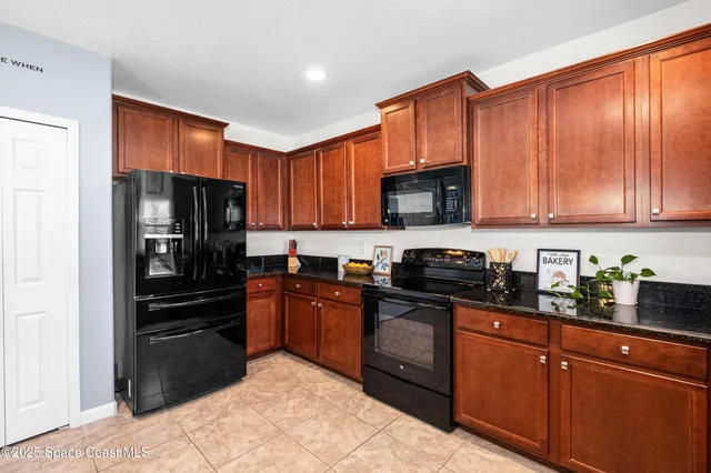 a kitchen with stainless steel appliances granite countertop wooden cabinets a stove top oven with a sink and dishwasher