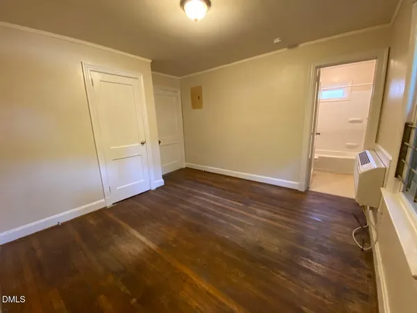 an empty room with wooden floor and door