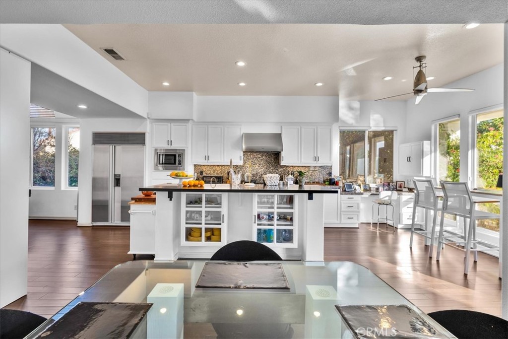4 Oakmont Drive Rancho Mirage, CA 92270 - Photo 14 of 73 a kitchen with stainless steel appliances wooden floor dining table and chairs