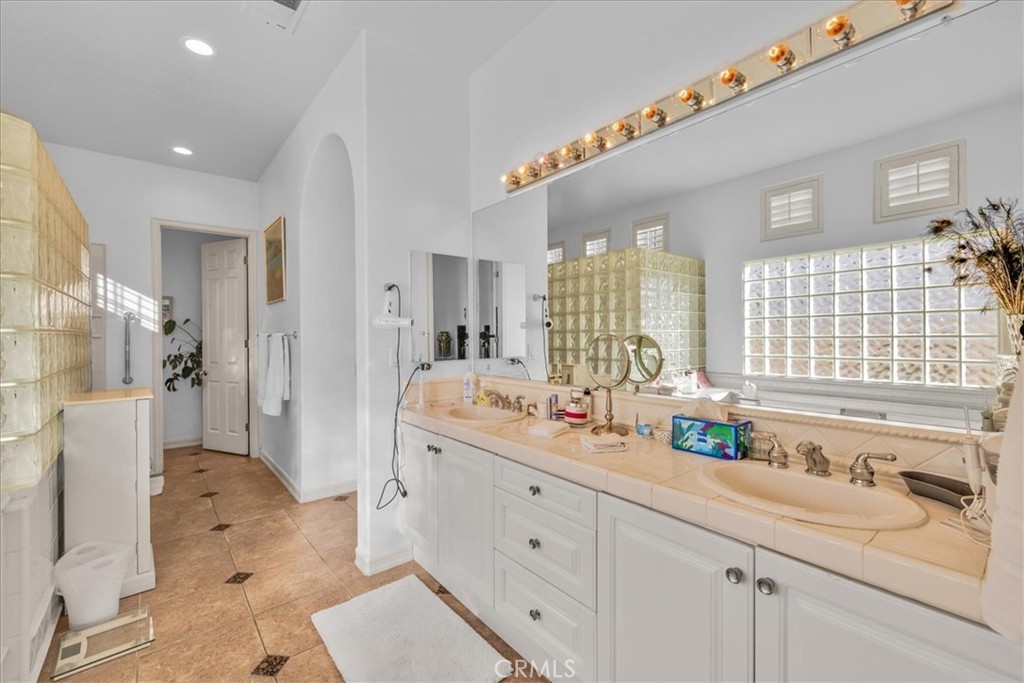 4 Oakmont Drive Rancho Mirage, CA 92270 - Photo 28 of 73 a spacious bathroom with double vanity a sink a mirror a bathtub and next to a window