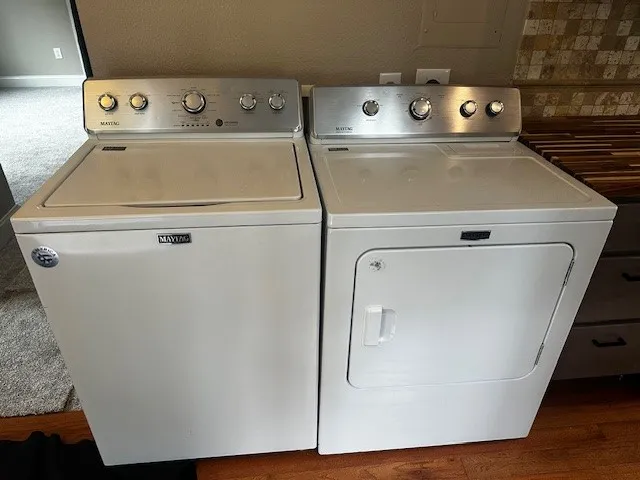 a close up view of washer and dryer with wooden floor